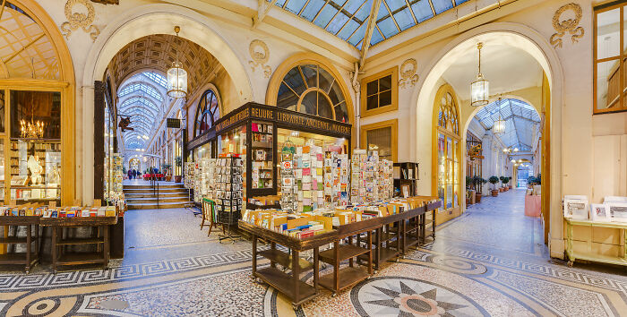 Grandiose and magical bookstore with beautiful architecture and intricate mosaic flooring in a bright, cozy setting.