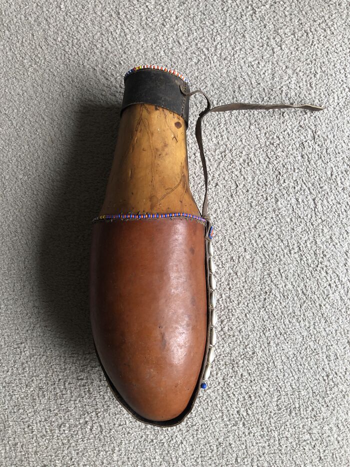 Handcrafted leather and wood item decorated with beads and shells, displayed as the weirdest item owned by a panda fan.