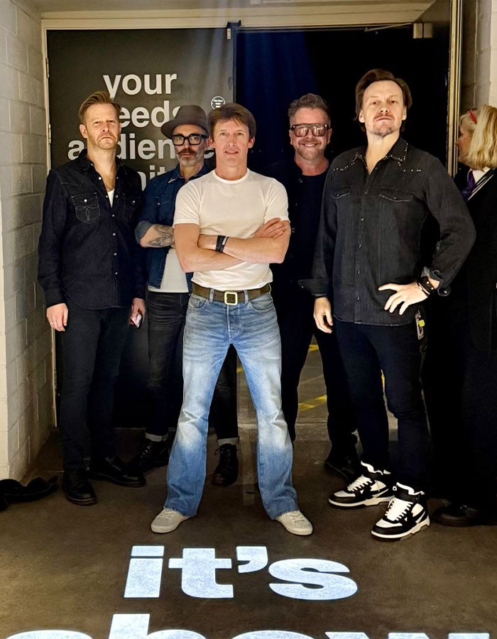 James Blunt standing with his band backstage, sharing the dark meaning behind hit song You’re Beautiful. James Blunt standing with his band backstage, sharing the dark meaning behind hit song You’re Beautiful.