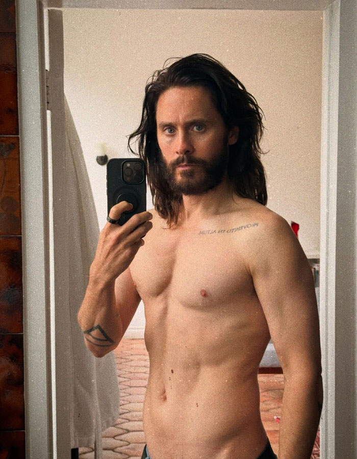Jared Leto shirtless taking a mirror selfie, with long hair and beard, related to inappropriate underage claims expos&eacute;.