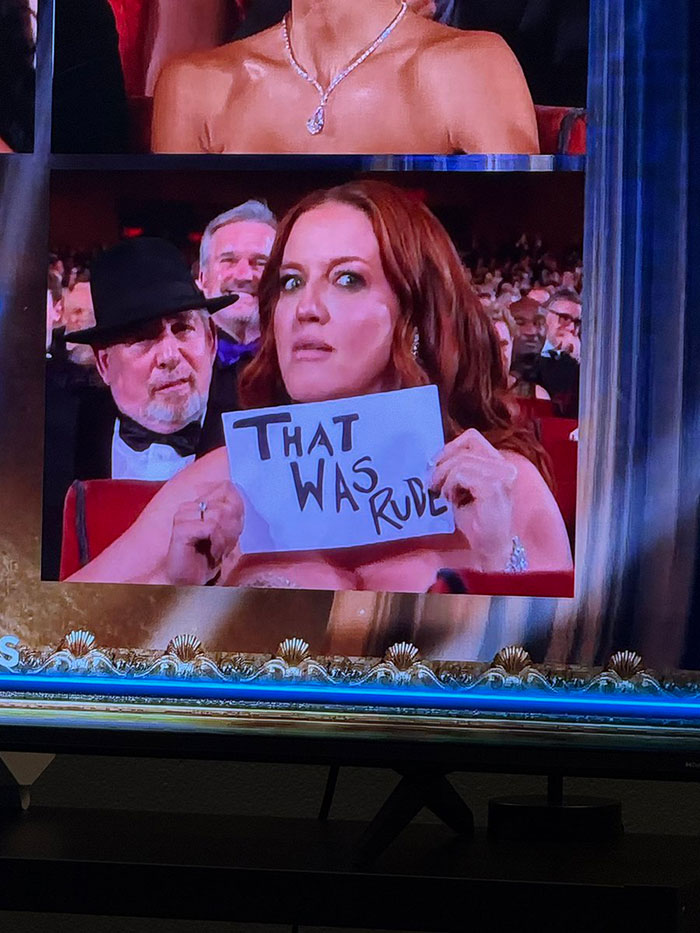 Woman at 2025 Tony Awards holding a sign that reads that was rude during a viral cringiest moment.