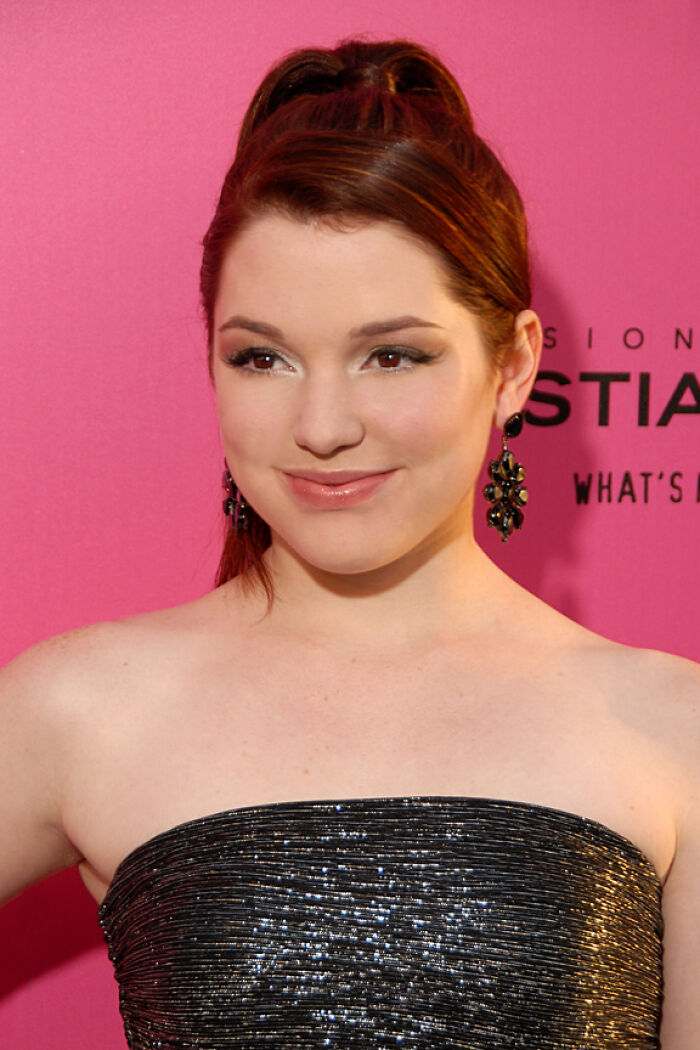 Young woman posing on a pink backdrop, representing former Hollywood stars who gave up the spotlight for normal careers.