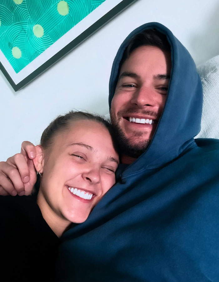 JoJo Siwa smiling and hugging a man, showing happiness and closeness amid record label controversy. JoJo Siwa smiling and hugging a man, showing happiness and closeness amid record label controversy.