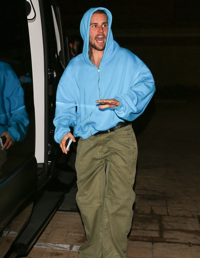 Justin Bieber in a blue hoodie and cargo pants during a wild exchange with paparazzi at night. Justin Bieber in a blue hoodie and cargo pants during a wild exchange with paparazzi at night.