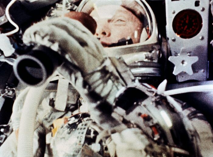 Astronaut in a space suit inside spacecraft, highlighting intriguing and bizarre astronaut facts in space exploration.