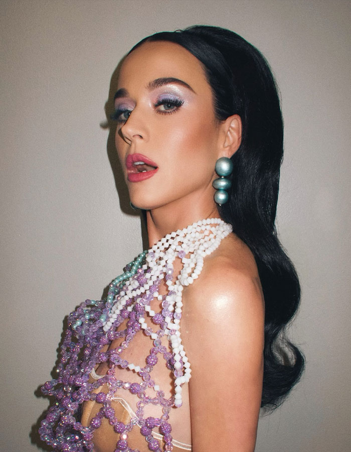 Katy Perry posing with dramatic makeup and pearl accessories, highlighting her style after breakup with Orlando Bloom.