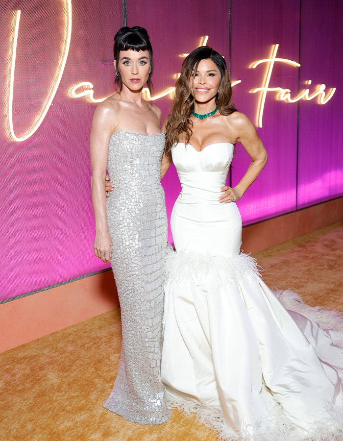 Katy Perry and another woman posing at Vanity Fair event, highlighting Katy Perry's messages following breakup with Orlando Bloom.