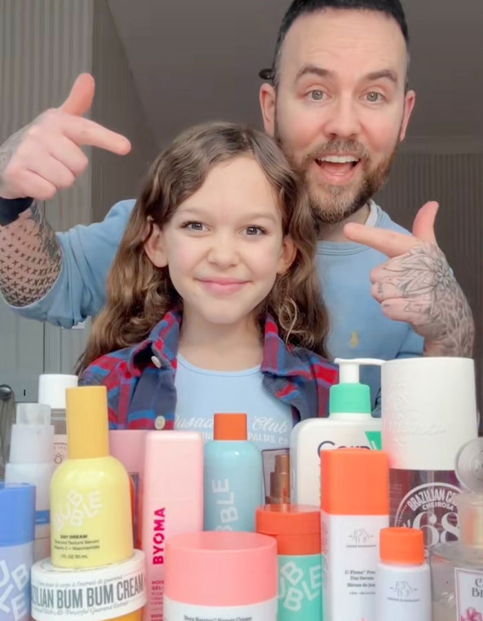 Man pointing at smiling pre-teen girl behind skincare products, highlighting concerns about social media trend and girls health.