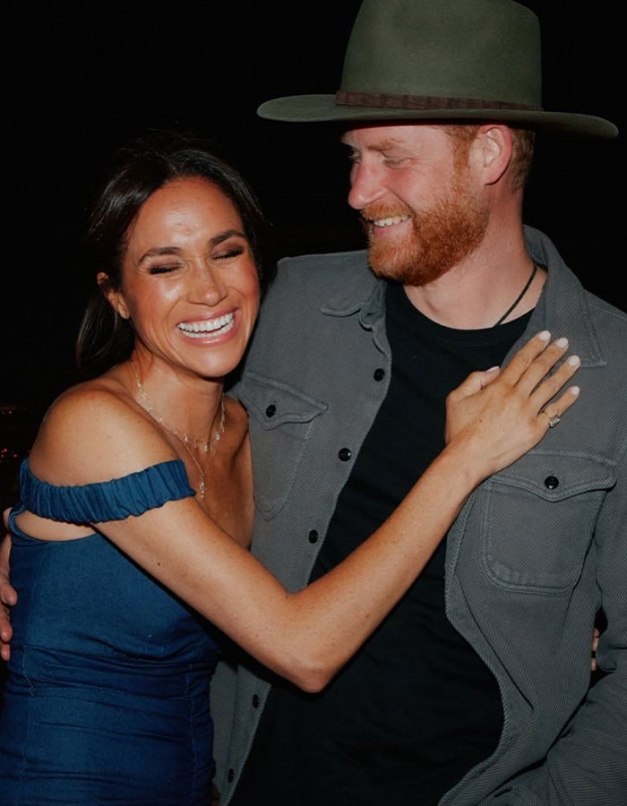 Prince Harry and Meghan Markle smiling together in an affectionate moment amid royal reconciliation talks.