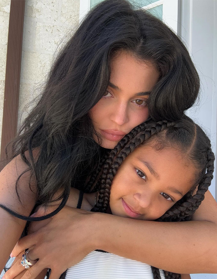 Kylie Jenner posing closely with her daughter, highlighting her figure after breast job confession in a casual setting.