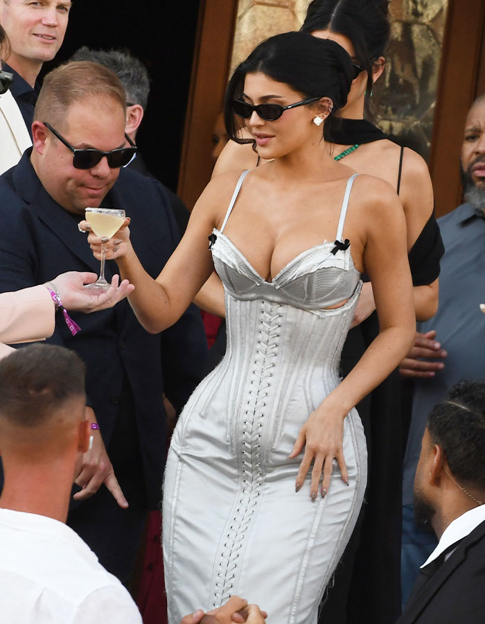 Kylie Jenner wearing a corset dress and sunglasses at Lauren S&aacute;nchez&rsquo;s wedding celebration, holding a cocktail glass.