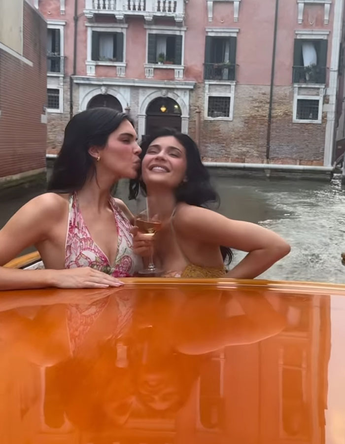 Kylie Jenner smiling with friend on a boat during Lauren S&aacute;nchez&rsquo;s wedding celebration by the canal.