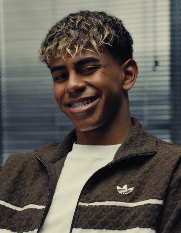 Smiling young man with braces and curly hair, wearing a brown jacket, relating to main SEO keywords about relationship and comment.