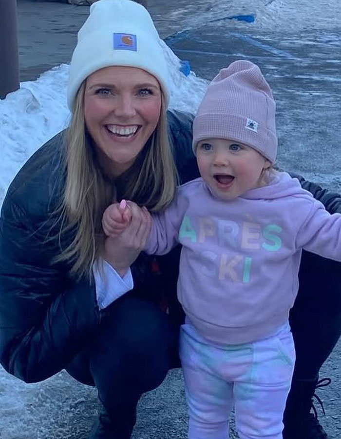 Smiling woman and toddler outside in winter gear, relevant to Real Housewives exec passes away during childbirth news.