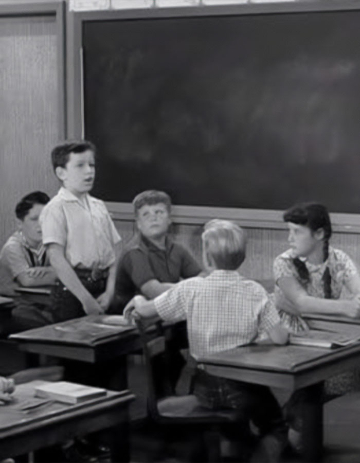 Black and white scene of cast from beloved 50s show in classroom setting, nearly 70 years after original release. Black and white scene of cast from beloved 50s show in classroom setting, nearly 70 years after original release.