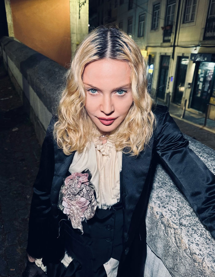 Madonna posing outdoors at night in a black outfit, relating to Madonna blasted by Hamilton star for disrespectful behavior.