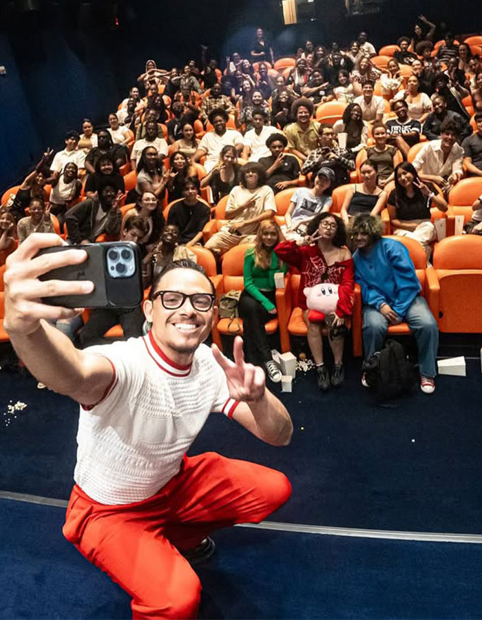 Hamilton star taking a selfie with a large audience in a theater setting during a show performance event.