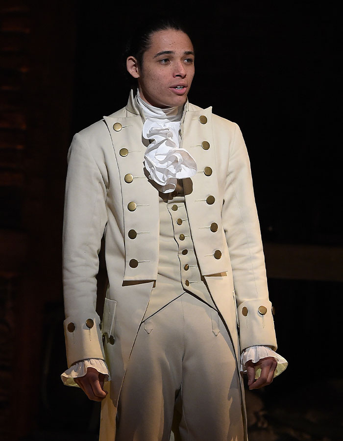 Hamilton star in period costume performing on stage, related to Madonna slammed for disrespectful behavior during show.