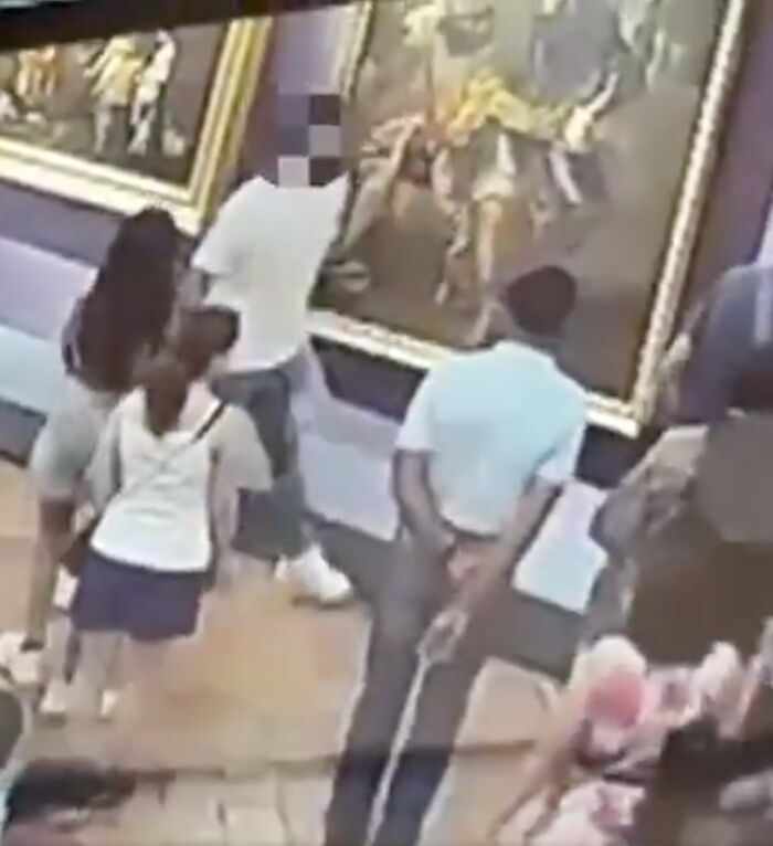 Museum visitors observe an 18th century painting damaged by a tourist in Italy while taking a selfie, sparking public outrage.