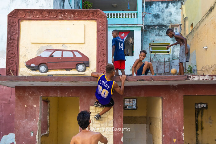 Children playing on a colorful rooftop in an urban setting, showing unseen realities captured by a photographer.