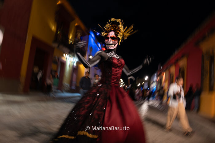 Person in traditional Day of the Dead costume and makeup captured by photographer revealing unseen realities.