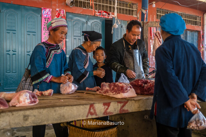 Local market scene showing the unseen realities of daily life with people buying and selling fresh meat products.