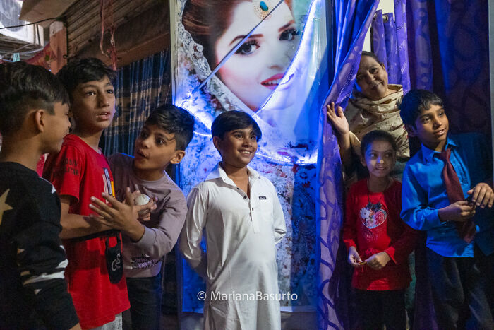 Children and an elderly woman gathered, captured in a vibrant photo revealing unseen realities of our world by a photographer.