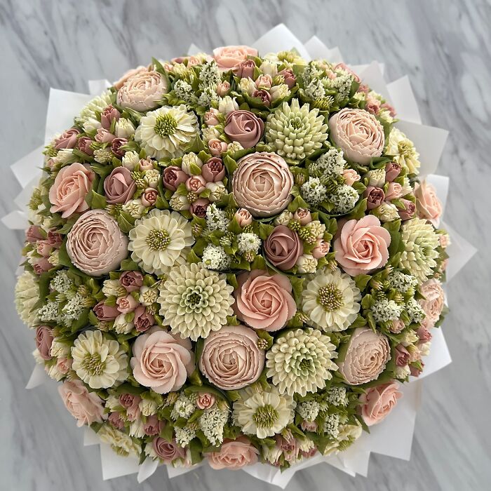 A stunning bouquet of baked goods resembling delicate flower arrangements with pastel pink and white blooms.