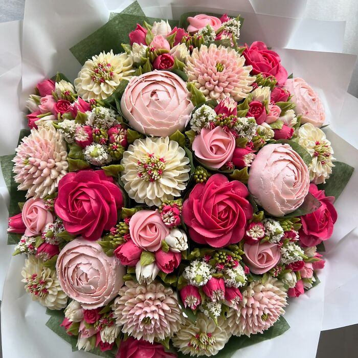 Bouquet of baked goods that look like flower bouquets with pink and white floral cupcake designs.