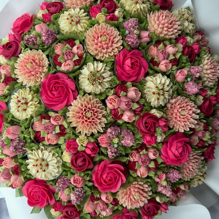 Bouquet of baked goods designed to look like detailed flower arrangements with vibrant pink, cream, and green colors.