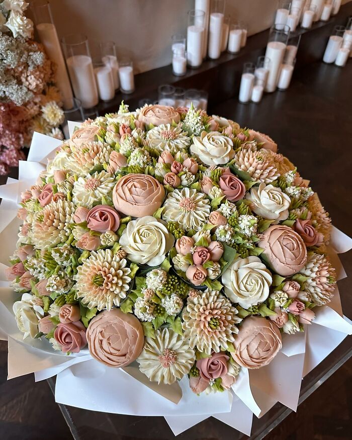 Bouquet of intricate baked goods resembling flowers in soft pastel colors, showcasing artistic cupcake decorating skills.