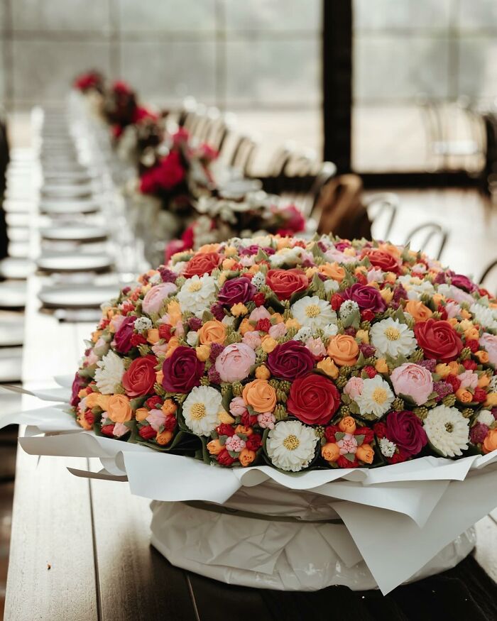 Colorful baked goods arranged to look like a flower bouquet displayed on a table at an event setting.