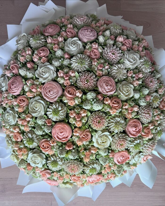 A large bouquet of intricately decorated baked goods resembling delicate pink and white flower bouquets.