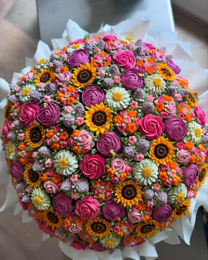 Colorful baked goods arranged to look like a vibrant flower bouquet with roses, sunflowers, and other floral designs.