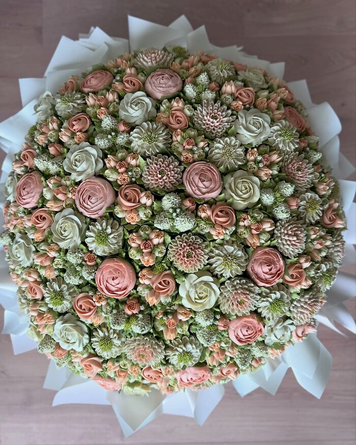 Bouquet of baked goods resembling flower arrangements with intricate pastel pink and white frosting details.