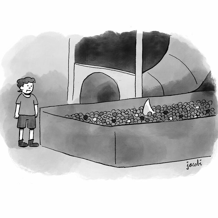 Boy looking nervously at a shark fin in a ball pit in a single-panel comic by Jacob Breckenridge.