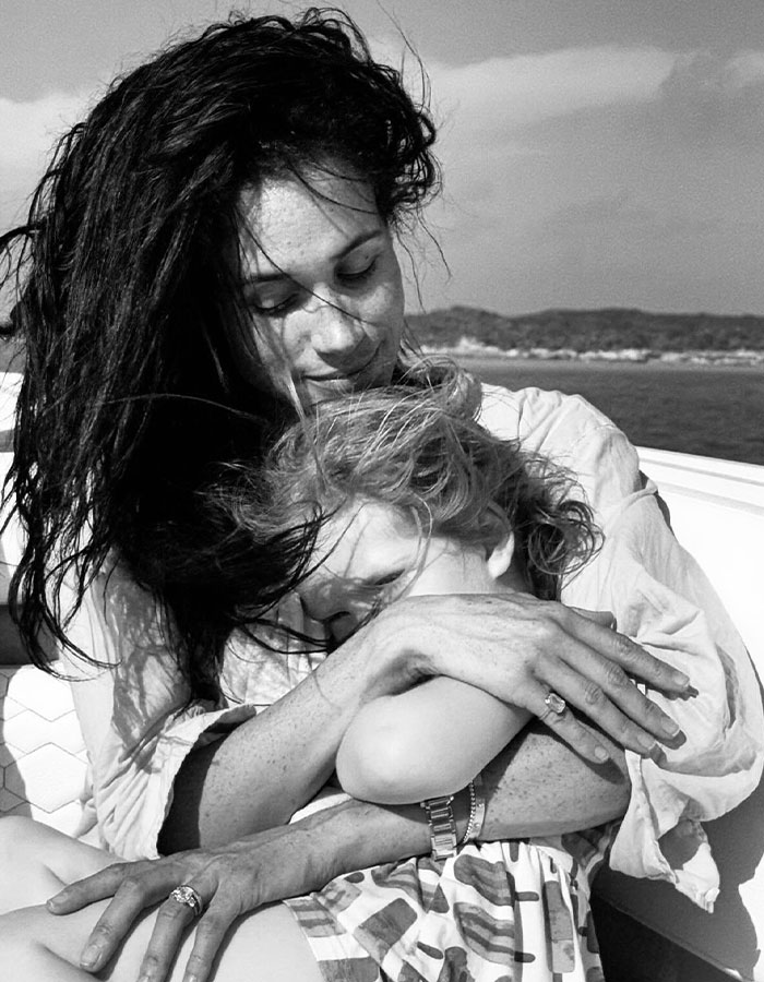 Meghan Markle embracing a child outdoors, a tender family moment amid Disneyland backlash over pregnancy dance.