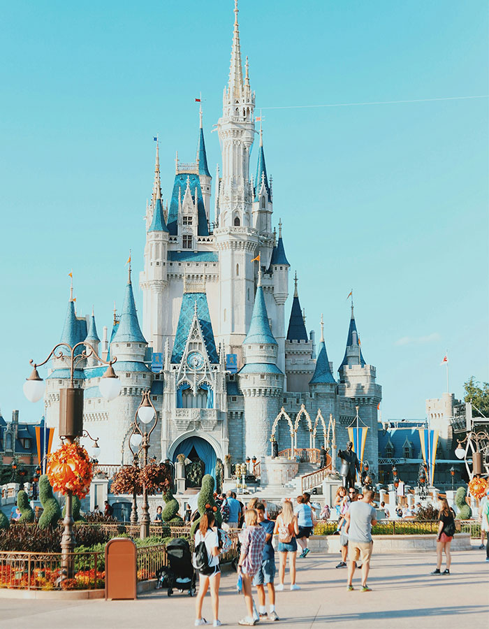 Disneyland castle with families visiting on a sunny day reflecting Meghan Markle&rsquo;s Disneyland family post backlash.
