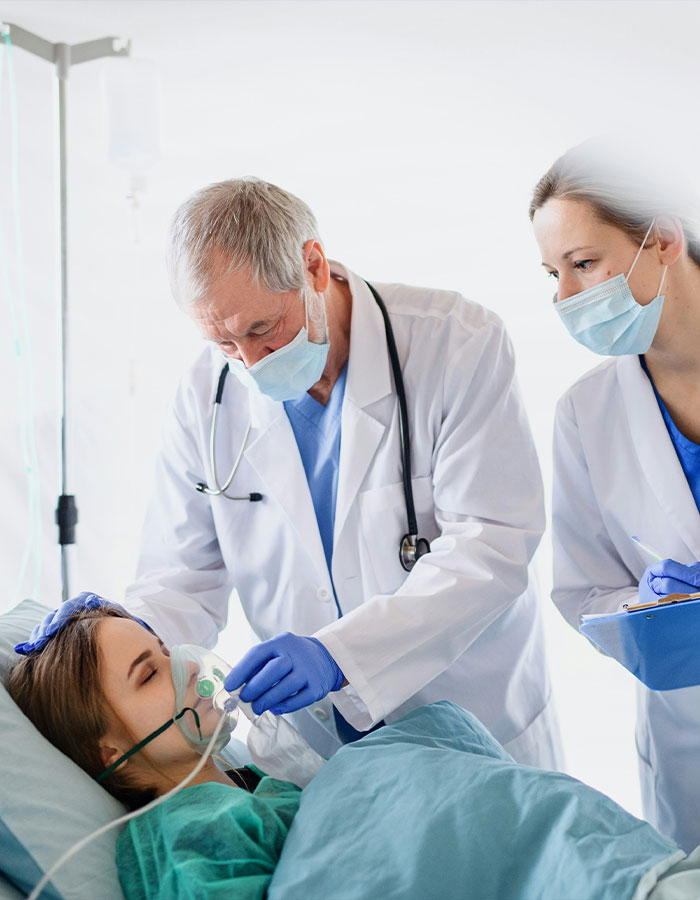 Doctor and nurse attending to a female model in hospital, providing care after a brutal attack in Dubai, helping her begin to speak.