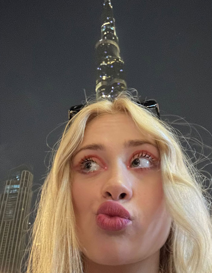 Blonde model in Dubai at night with Burj Khalifa in background, related to model brutally attacked in Dubai news.