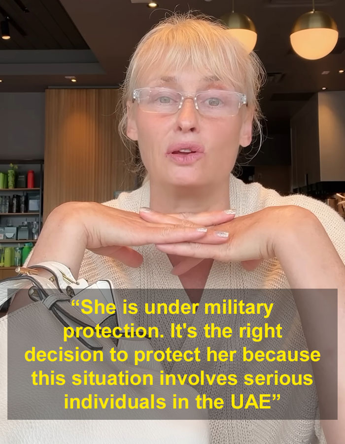 Woman wearing glasses speaking in a cafe, discussing model with broken bones and ties to influential family in Dubai case.