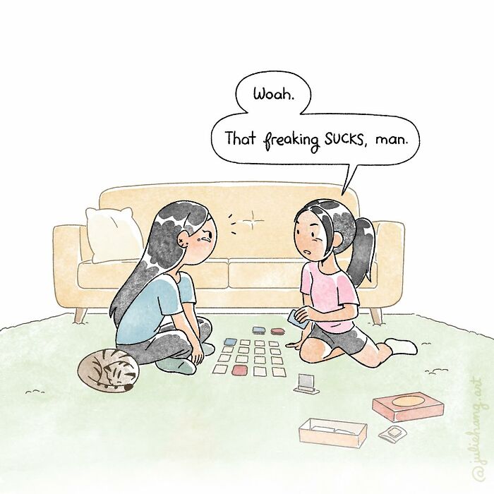 Two girls sitting on the floor playing a card game, capturing the ups and downs of life in a heartfelt moment.