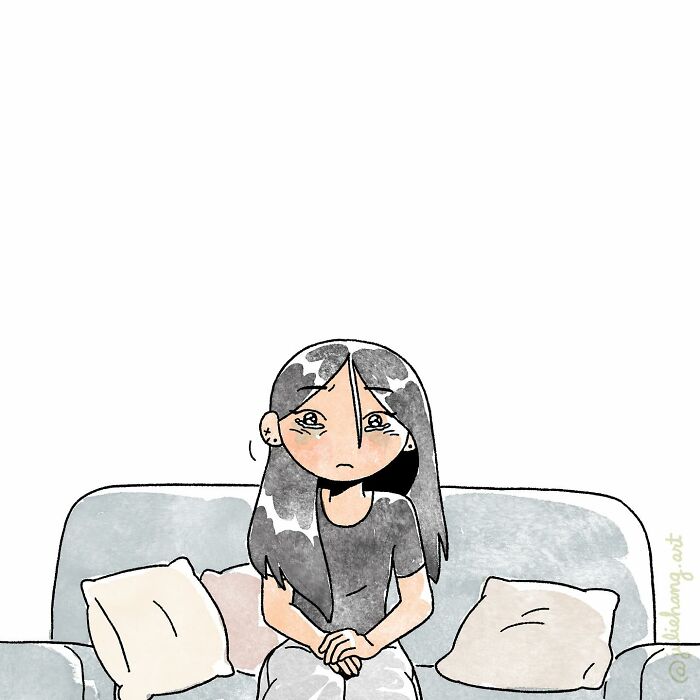 A woman with long dark hair sitting on a couch looking sad, capturing the ups and downs of life stories.
