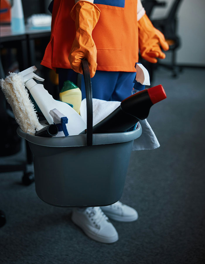 Person in orange gloves holding a cleaning supplies bucket, highlighting mom&rsquo;s insulting birthday gift backlash concept.