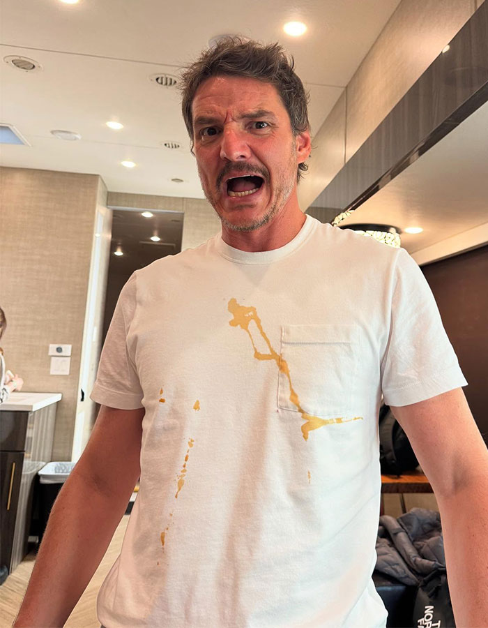 Pedro Pascal reacting with surprise, wearing a stained white t-shirt indoors, linked to J.K. Rowling Death Eater controversy. Pedro Pascal reacting with surprise, wearing a stained white t-shirt indoors, linked to J.K. Rowling Death Eater controversy.