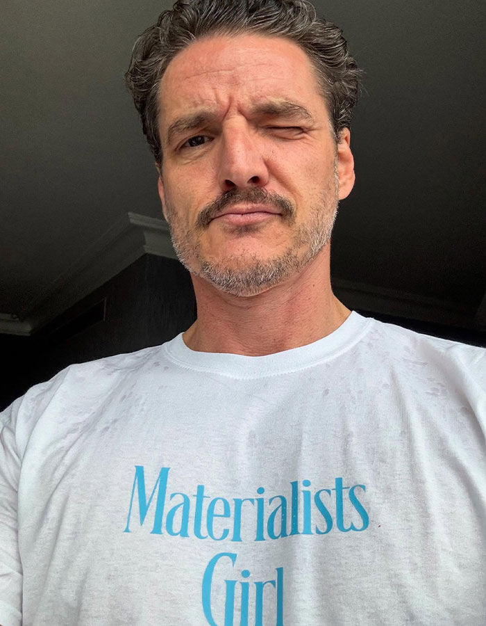 Pedro Pascal posing for a selfie, wearing a white shirt with blue text, linked to J.K. Rowling and Death Eater claims. Pedro Pascal posing for a selfie, wearing a white shirt with blue text, linked to J.K. Rowling and Death Eater claims.