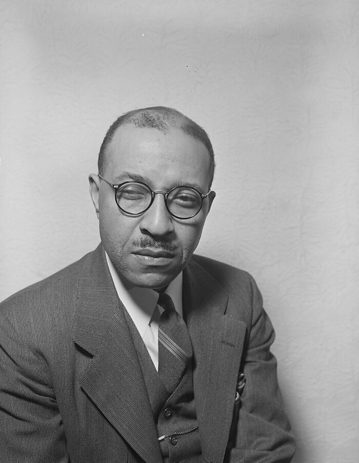 Portrait of a man in glasses and suit representing a defining moment in the Harlem Renaissance era.