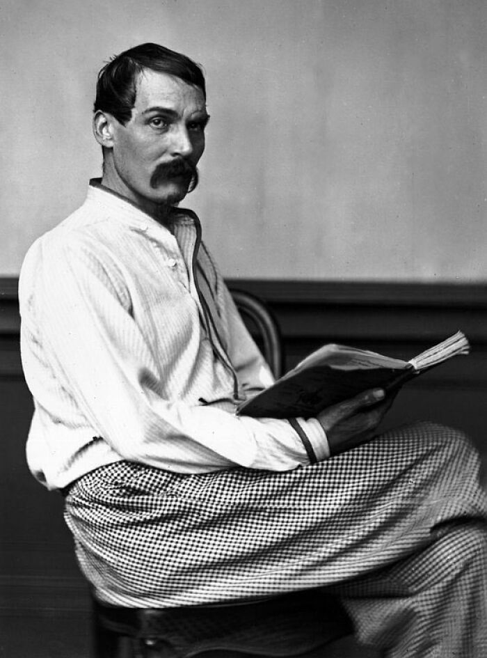 Black and white photo of a good looking historical figure sitting and reading a book, representing famous names from history.