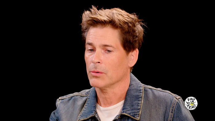 Actor Rob Lowe in a denim jacket discussing Hollywood hypocrisy about how men age like fine wine.