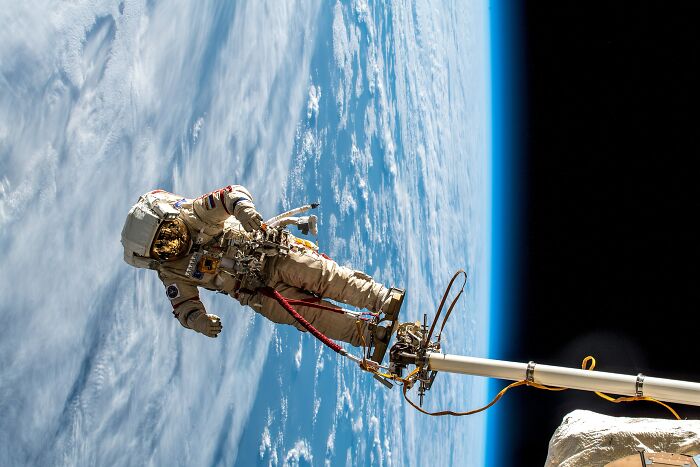 Astronaut performing a spacewalk above Earth, showcasing intriguing and bizarre astronaut facts in outer space.